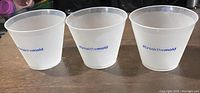 Side view of three clear plastic cups showing the '#breakthemold' text in blue