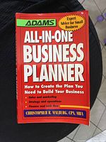 Front cover of the Adams All-In-One Business Planner book showing title, author, and key topics: sales and marketing, strategy and operations, and finance.
