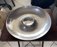 Top down view of large round silver-tone dipping serving tray showing wide rim and central raised dip section.
