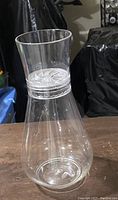 Side view of clear glass carafe showing hourglass shape