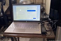 Open view of the laptop connected to charger showing Windows setup screen