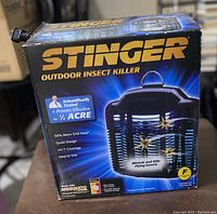 Front view of the Stinger outdoor insect killer box showing product branding and features.