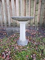 Fully assembled concrete bird bath showing fluted column stand and wide shallow bowl in outdoor setting.