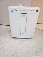 Front view of white Sharp air cleaner showing control panel with buttons and indicator lights.