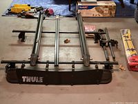 Complete roof rack components laid out showing crossbars, bike mounts, wind deflector, and hardware