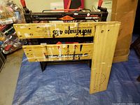 Full view of folded Workmate 425 workbench with bamboo boards and red clamp handles visible