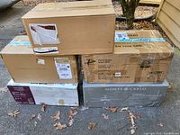 Stacked cardboard boxes containing multiple ceiling fans and a lantern fixture
