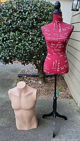 Photo showing both mannequins outdoors: a male torso mannequin in flesh tone with no head or arms, and a female red fabric dress form mannequin on a black pedestal stand.
