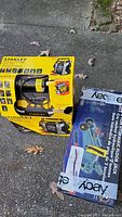 Box of Stanley Portable Power Jump Starter 1000A with compressor, yellow and black unit visible on box.
