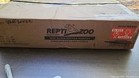Original shipping box for the Repti-Zoo Reptile Aquarium with branding and product details visible.