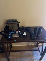 Photo of entire assortment laid out on table: camera, lenses, light meter, carrying case, CD