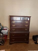 Front view of Ethan Allen dresser showing all drawers and brass handles.