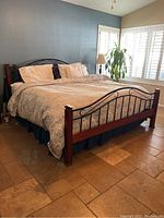 King size bed fully assembled showing wood posts and metal scrolling headboard and footboard