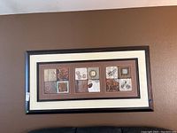 Frontal view of the rectangular framed wall art showing three panel sections with abstract and natural painted appliqué artwork in earthy tones without glass.