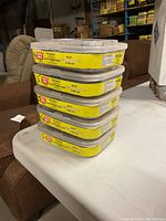 Stacked five packs of Griprite 2" smooth shank phosphate coated nails with yellow and clear packaging showing product details.
