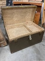 Open trunk showing internal wooden compartmentalized sections with natural wood finish and reinforced metal edges.