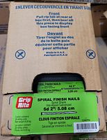 Box partial view showing 20 packages of Grip-Rite Spiral Finish Nails, green labeled box with product details in English and French, manufactured in UAE.