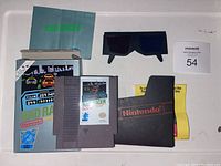 Full lot showing Rad Racer cartridge, box, manual, sleeve, and 3D glasses laid out on white surface.