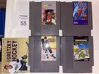 Four Nintendo NES game cartridges laid out, labels visible: Contra, Legendary Wings, Gretzky Hockey, Teenage Mutant Ninja Turtles.