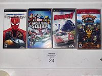 Four Sony PSP game cases including The Amazing Spider-Man, Marvel Super Hero Squad, Burnout, and Ratchet & Clank: Size Matters Greatest Hits edition, shown side by side on a white surface.