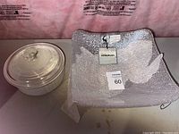 Round clear glass bowl with lid featuring a knob, shown next to one of the Vetropuro bowls for size comparison.