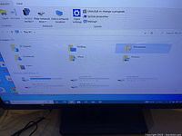 Monitor screen showing Windows Explorer with drives C, D, E
