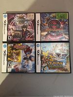 Top-down view of the four Nintendo DS games in their original cases showing cover artwork and price stickers on some cases.