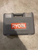 Closed black Ryobi carrying case with large red Ryobi label and text '215 piece super drilling and driving kit'