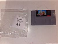 Photo of Super Mario Kart SNES cartridge next to a plastic bag with lot number label.