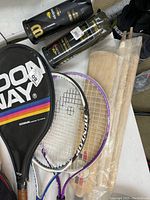 Photo showing two tennis racquets (Donnay and Wilson), tennis ball tubes and black Donnay cover.