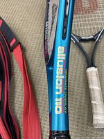 Close-up of Allusion 110 Graphite Overlay tennis racquet frame, metallic blue color with brand and model visible.