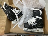 Pair of Bauer Nexus 22 kids ice hockey skates in original box, black with white laces and white interior padding