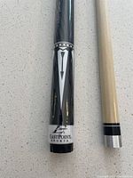 Close up of the bottom segment of the black Eastpoint Sports pool cue showing branding and design details.