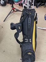 Black and yellow Cobra golf bag with foldable legs, padded shoulder strap, and various pockets.