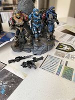 Photo showing three Noble Team figures on rocky base with weapons and decals in foreground.
