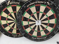SwiftFlyte and Sportcraft dart boards side by side showing brand logos and boards' condition.