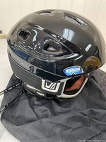 Photo of black Scott Venue ski helmet with attached goggles showing ventilation openings and logo.