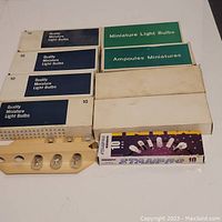 Boxes of miniature light bulbs showing packaging and bulbs in plastic strips.