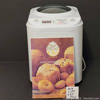 White Bread Chef bread machine with instruction booklet in front showing bread images and brand name.