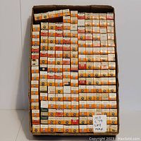 Full view of many boxed RCA and GE electron tubes arranged in rows inside a large cardboard box.