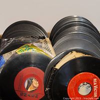 Multiple vintage 45 RPM vinyl records stacked together, some with visible labels including RCA Victor.