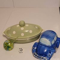 All three items together: green polka-dot covered baking dish, blue car cookie jar, green-yellow blown glass hanger