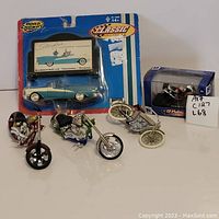 Lot of 5 motorcycles and one Starfire convertible toy in packaging displayed on white surface.
