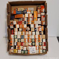Overview photo showing numerous vacuum tubes in original boxes arranged in rows inside a cardboard tray.
