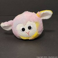 Front view of the plush lamb showing facial features and colors.