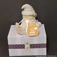 Front view of ceramic Santa Slumber scent warmer atop its original box, with Saddle Up scented wax bar attached