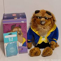 Photo showing Beast plush toy next to box and sealed scent pack