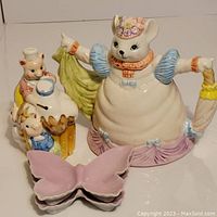 Photo showing ceramic cat-shaped tea pot, butterfly dishes, and bear family peggy bank