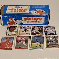 Photo of the blue and white 500 count vending pack box of 1991 Tops picture baseball cards with several cards displayed in front.