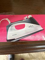 Close-up photo of the Eurosteam Platinum Compact iron on its product box, showing the black and white design and 1000W power specification.